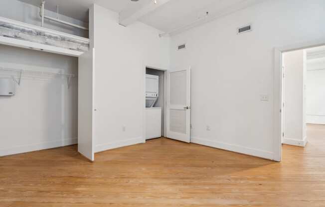 A large empty room with wooden floors and white walls.