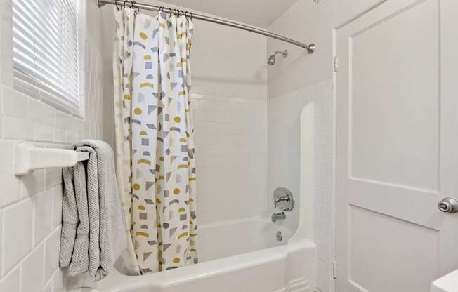 a bathroom with a shower curtain and a white tub