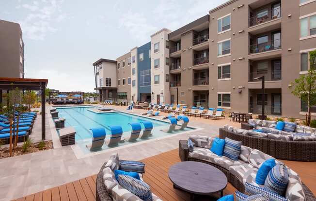 an outdoor pool with lounge chairs and tables at the bradley braddock road station apartments