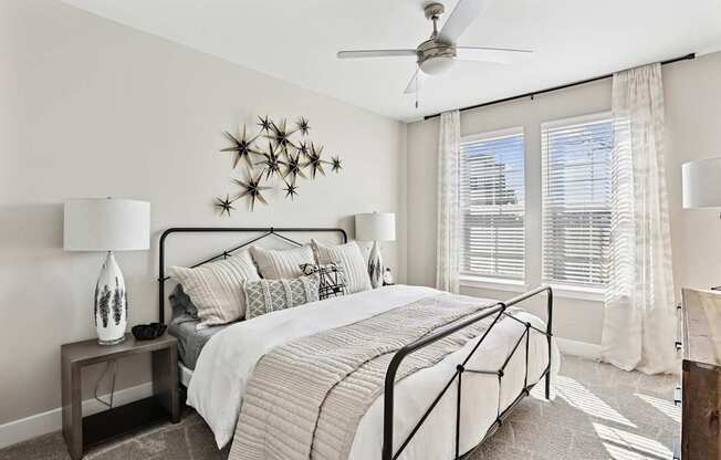 A bedroom with a large bed and a ceiling fan.