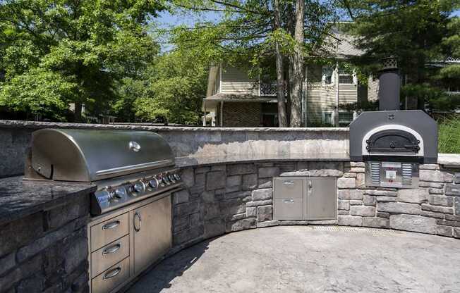 A stainless steel outdoor kitchen with a grill and oven.