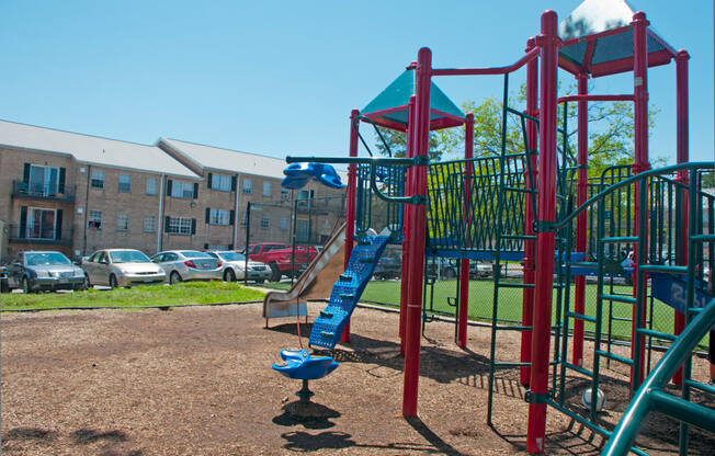 a playground with a slide in front of an apartment building