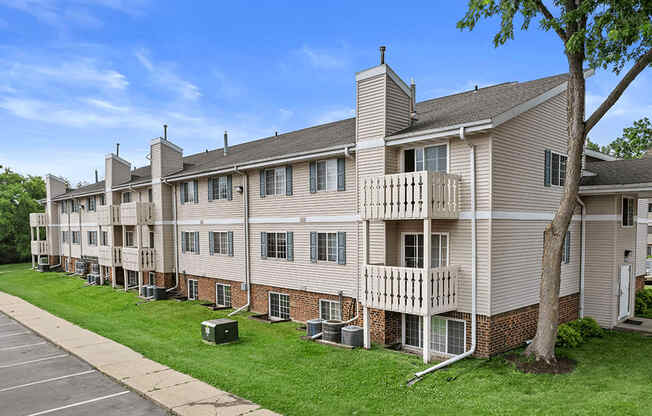 an image of an apartment building with green grass and trees at sun valley apartments