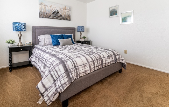 a bedroom with a bed and a dresser with a nightstand and a window