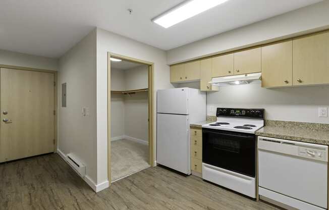 a kitchen with a white refrigerator freezer next to a stove top oven at Excalibur Apartment Homes, Bellevue
