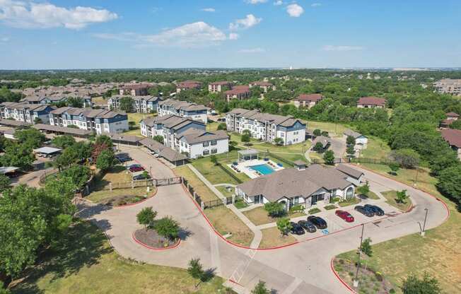 an aerial view of an apartment complex with cars parked in a parking lot