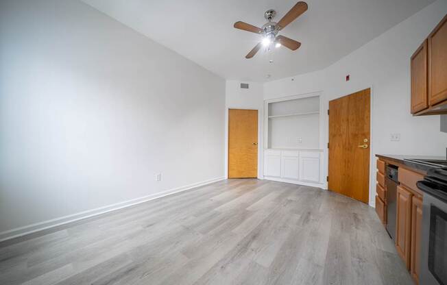 A room with a ceiling fan and wooden flooring.