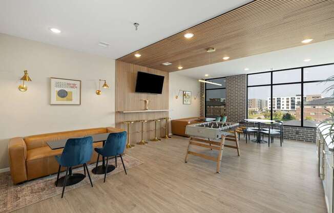 A living room with a brown couch, blue chairs, and a wooden table.