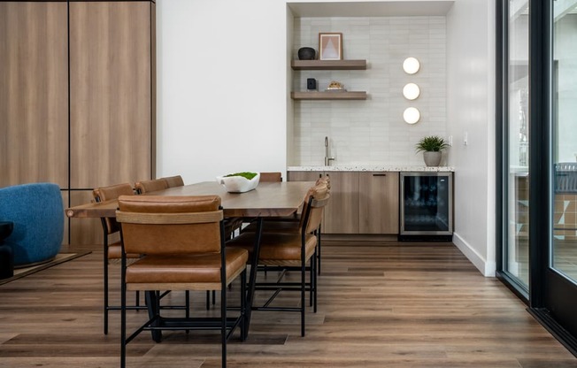 a dining room and kitchen with a wooden table and chairs