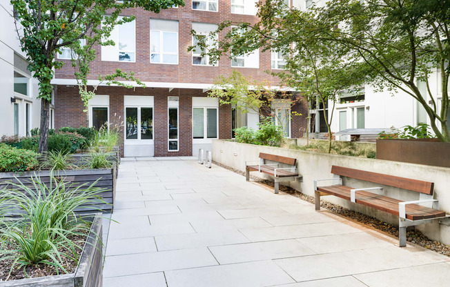 A courtyard with benches and a building in the background.