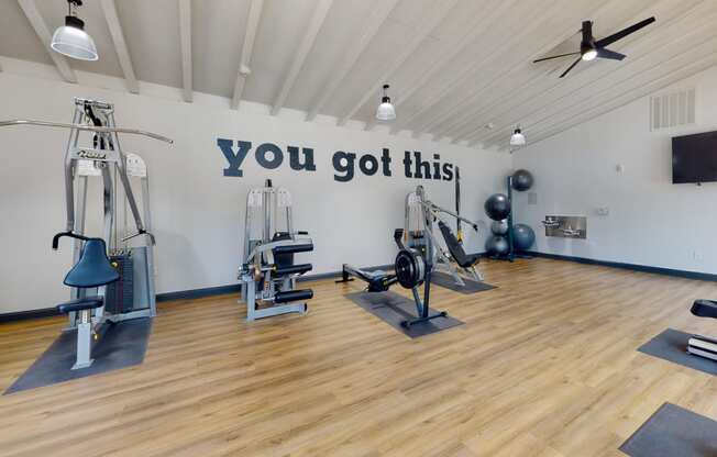 a gym with exercise equipment and a large sign that says you got this