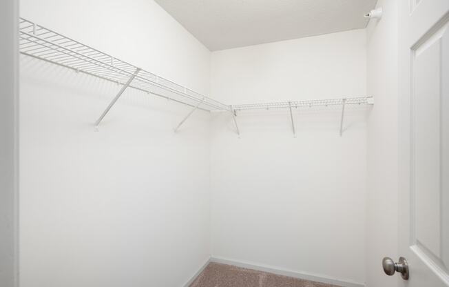 an empty closet with a metal rack on the wall