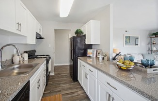 a kitchen with white cabinets and a granite counter top