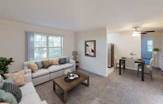 living area with sofa, coffee table, windows and view of dining area at manor village apartments in washington dc