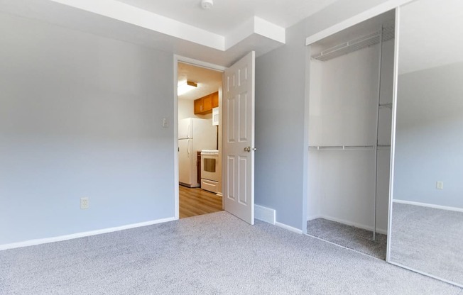 A room with a white door and a grey carpet.