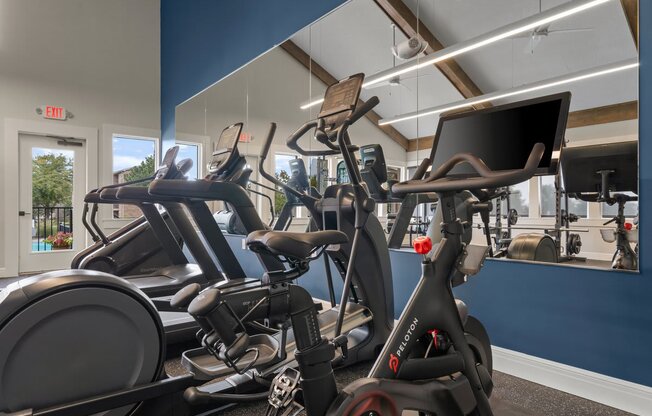 a gym with various exercise bikes and a monitor