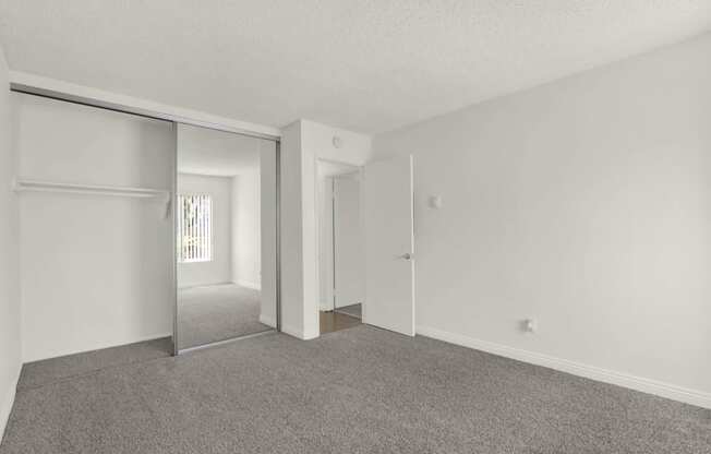 the living room of an apartment with white walls and carpet  at Willow Tree Apartments, California, 90505