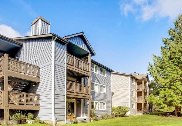 a row of houses with balconies and a green lawn