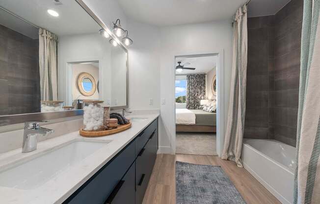 A bathroom with a white sink and a mirror above it.