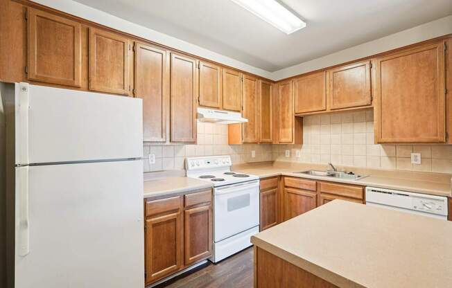 A kitchen with wooden cabinets and white appliances.
