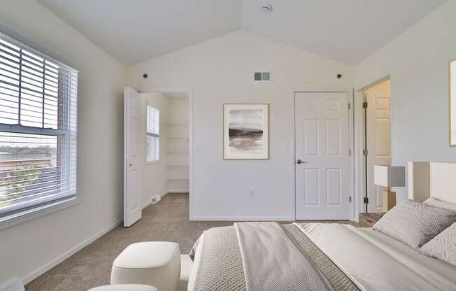 A bedroom with a bed, chair, and picture on the wall.