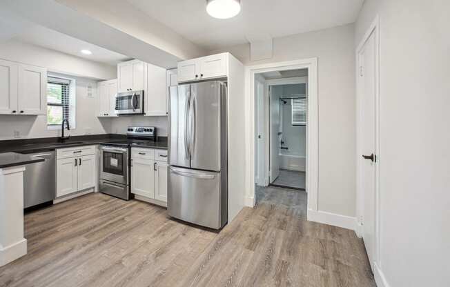 a renovated kitchen with stainless steel appliances and white cabinets