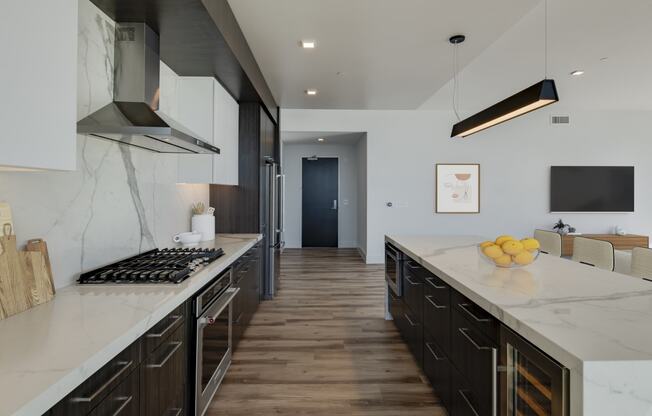 a large kitchen with marble counter tops and wooden floors