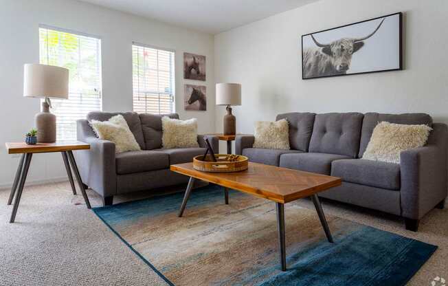 A living room with a grey couch and a wooden coffee table.