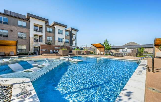 A large swimming pool in front of apartment buildings.