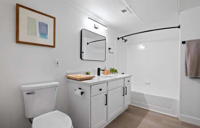 a white bathroom with a white toilet and a white sink