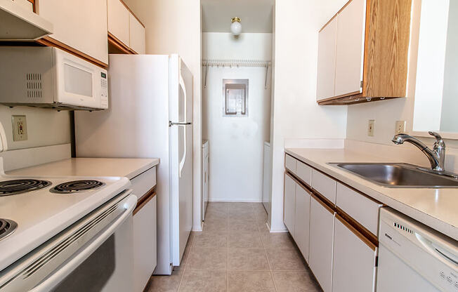 a kitchen with white appliances and wooden cabinets