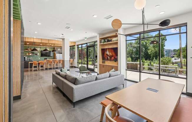 A modern living room with a grey sofa and a wooden table at Link Apartments® CYKEL Apartments, Charlotte