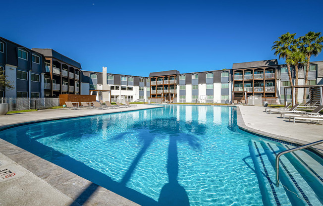 a large swimming pool with a building in the background