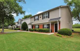 Building exterior featuring covered front door, large windows and paved walkway.