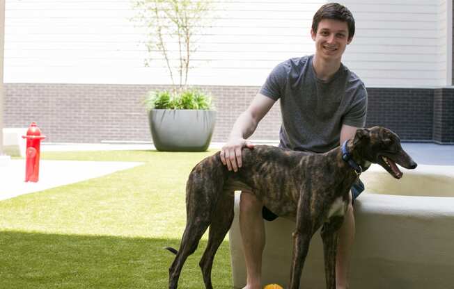 a man sitting on a couch with his two dogs