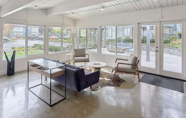 a resident lounge with a large window and a view of an outdoor seating area  at 3030 Lake City, Seattle, WA, 98125