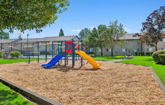 A playground with a blue and yellow slide.