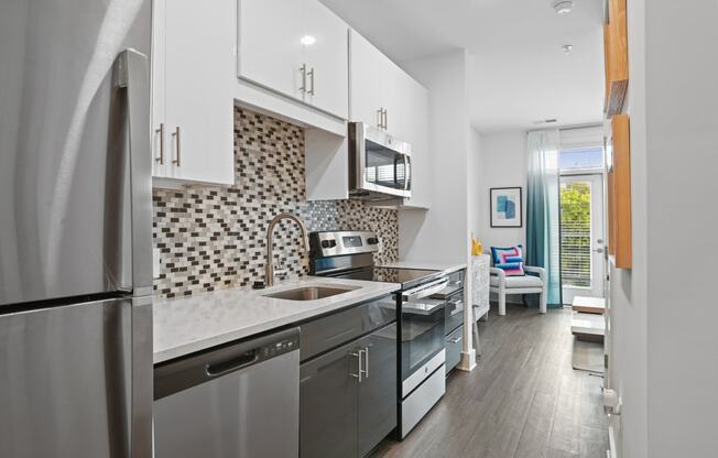 Studio kitchen with stainless steel appliances and quartz counters at Link Apartments® Mint Street in Uptown Charlotte, NC. at Link Apartments® Mint Street, Charlotte, NC, 28203