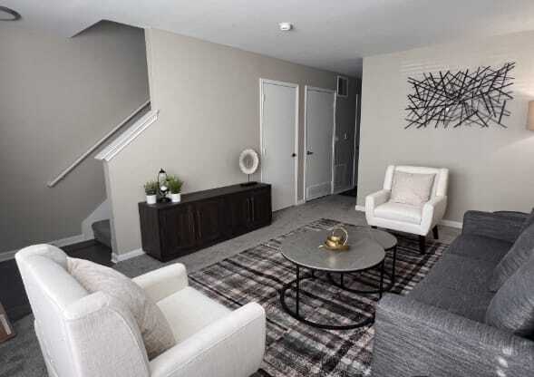A living room with a grey couch, a white chair, and a coffee table.