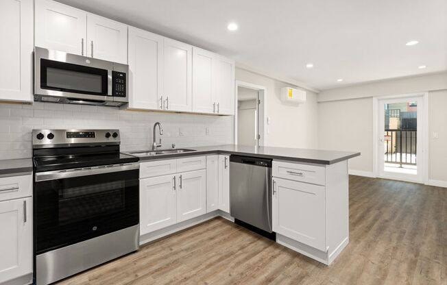 a kitchen with white cabinets and a stove and a microwave