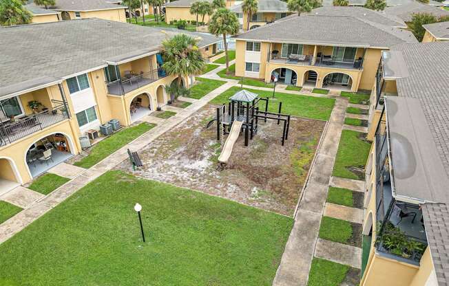 an aerial view of a playground in the yard of an apartment building