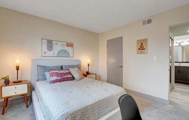 A bedroom with a bed, a chair, and a painting on the wall.
