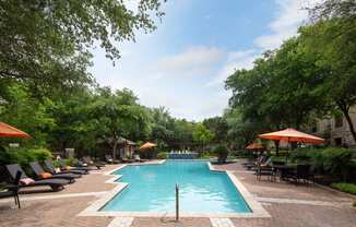 a swimming pool with lounge chairs and umbrellas