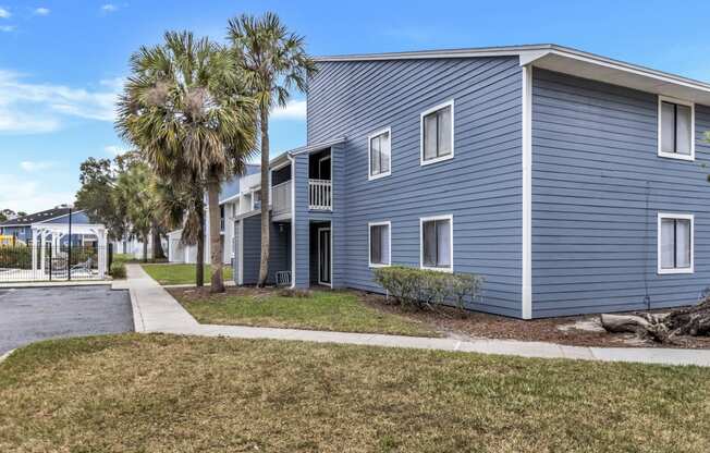 a blue building with palm trees in front of it