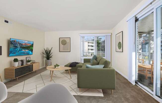 A living room with a green couch, a wooden table, and a painting on the wall.