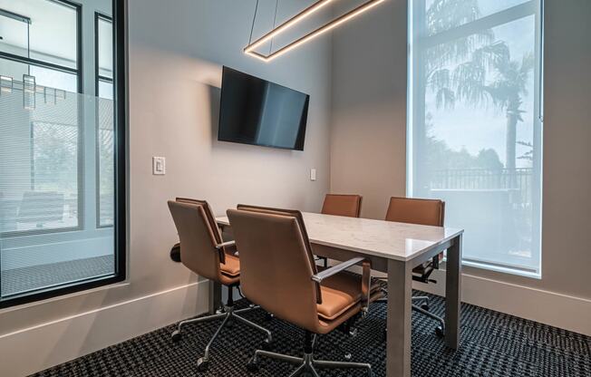 a conference room with a table and chairs and a tv at Altis Grand Suncoast, Land O' Lakes, FL