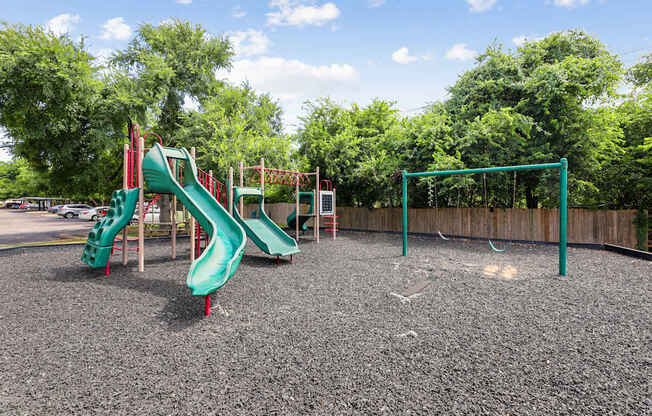A playground with a green slide and a red slide.
