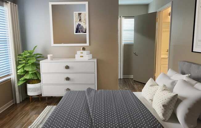 a bedroom with a bed and a dresser and a mirror