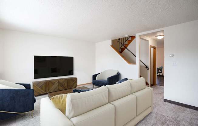 A living room with a white couch and a television. West Fargo, ND Sheyenne Terrace Townhomes