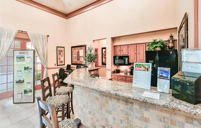 a lobby with a bar and a counter with chairs